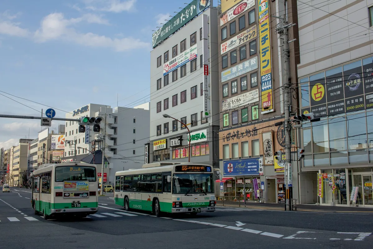 日本の市街地を走る白と緑の路線バス