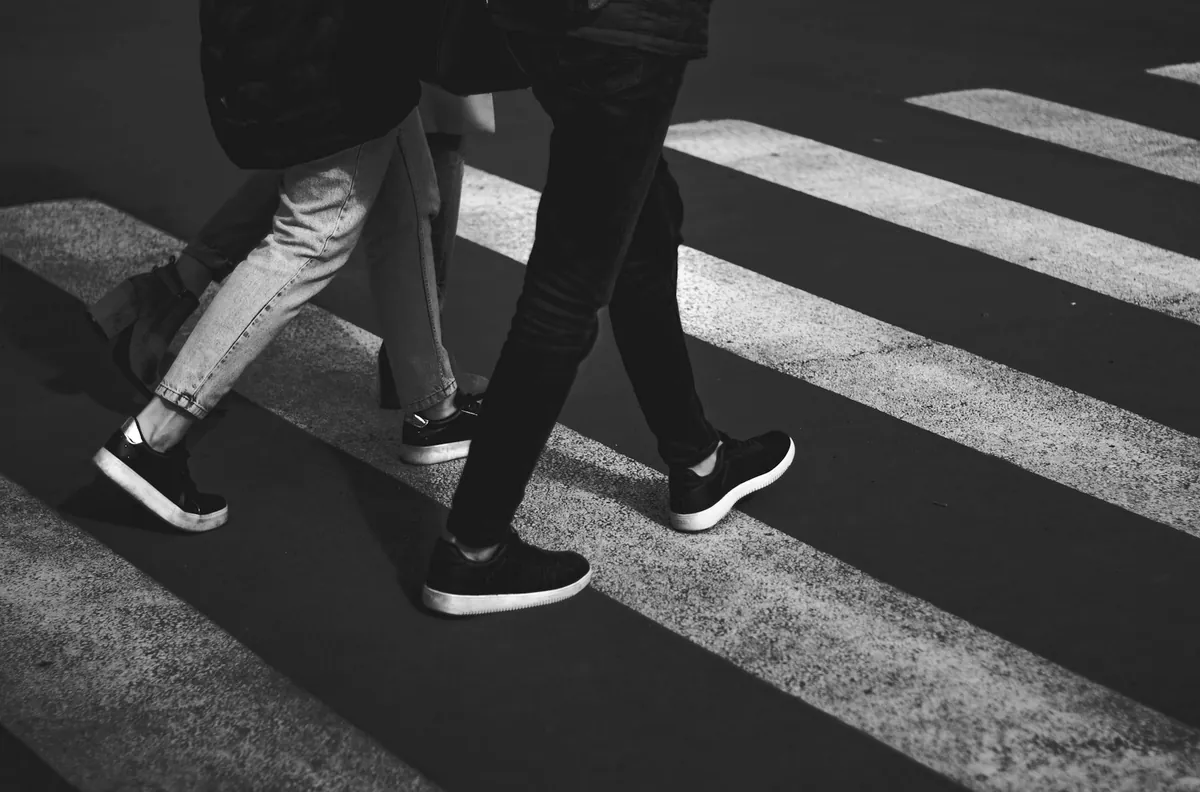 横断歩道を歩く人の足元だけを写した写真